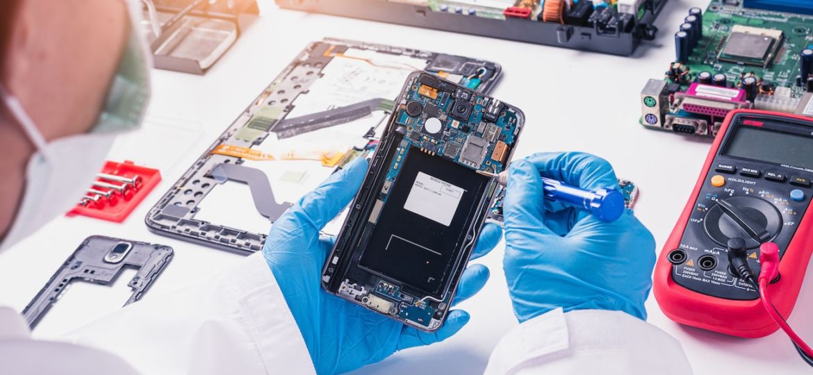 The abstract image of the technician assembling inside of smartphone by screwdriver in the lab. the concept of computer hardware, mobile phone, electronic, repairing, upgrade and technology.